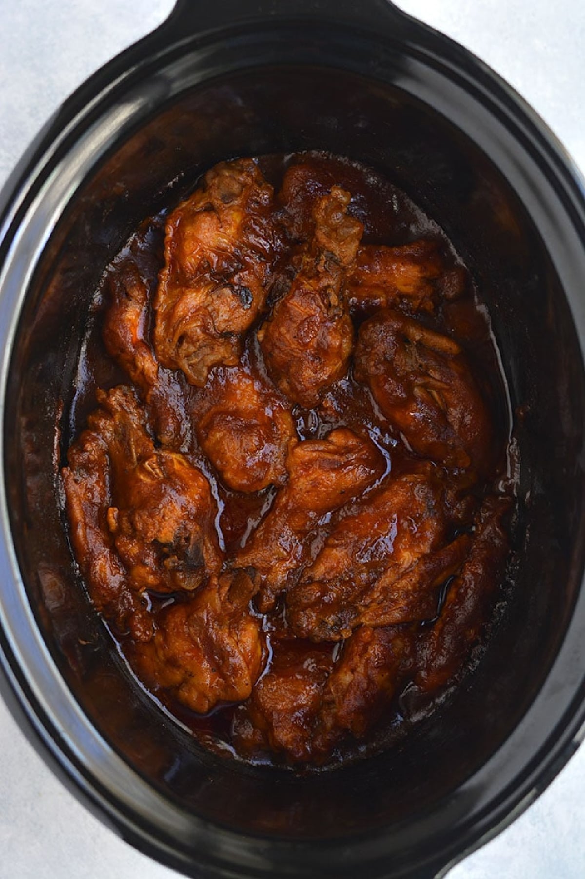 chicken wings in a slow cooker with bbq sauce.