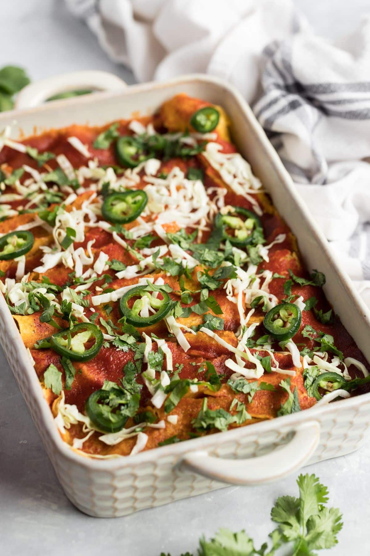 A casserole dish of high protein chicken enchiladas on the table.