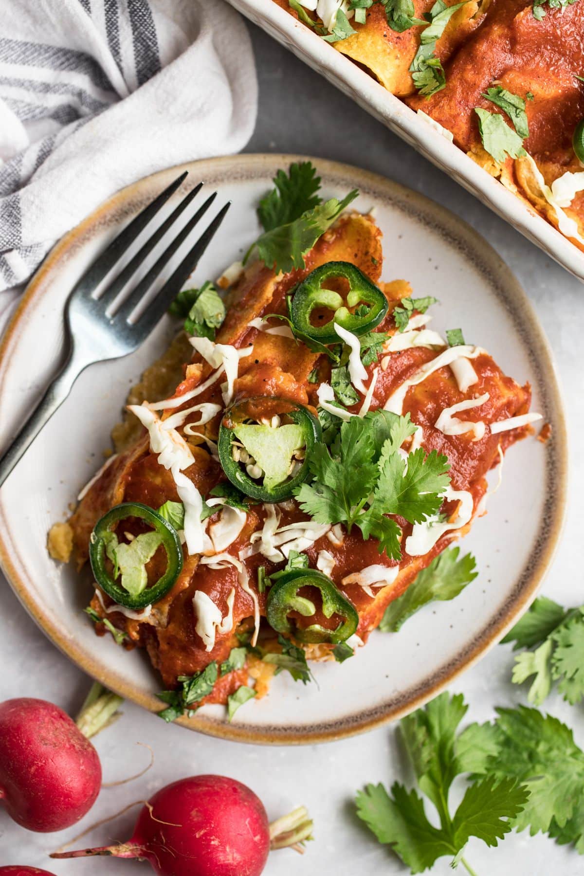 High Protein Chicken Enchiladas! These skinny enchiladas are made with a few simple, healthy swaps. They are creamy on the inside and spicy on the outside. Only 320 calories per serving and made with real food! Gluten Free + Low Calorie
