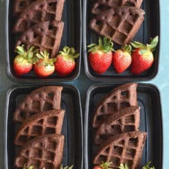 3 chocolate waffle quarters stacks in a meal prep container with strawberries.