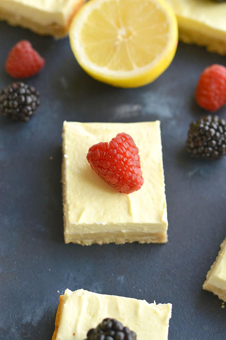 Skinny Greek Yogurt Lemon Bars! These creamy bars have a gluten free shortbread crust with a stevia sweetened Greek yogurt custard layer on top that's bursting with lemon flavor! These lightened up bars are baked to perfection for the ultimate low calorie dessert! Gluten Free + Low Calorie