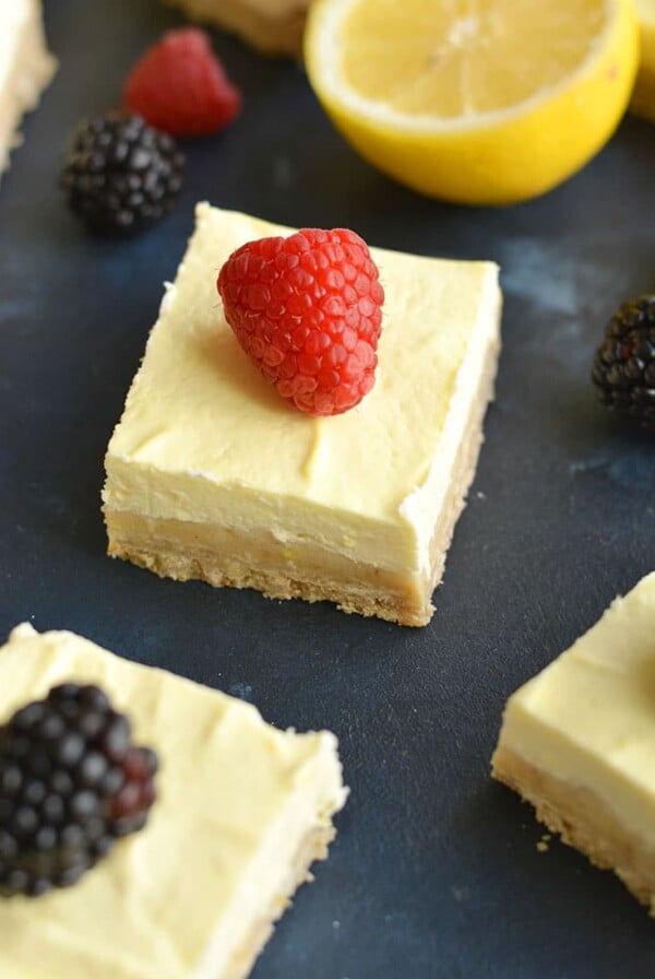 Skinny Greek Yogurt Lemon Bars! These creamy bars have a gluten free shortbread crust with a stevia sweetened Greek yogurt custard layer on top that's bursting with lemon flavor! These lightened up bars are baked to perfection for the ultimate low calorie dessert! Gluten Free + Low Calorie