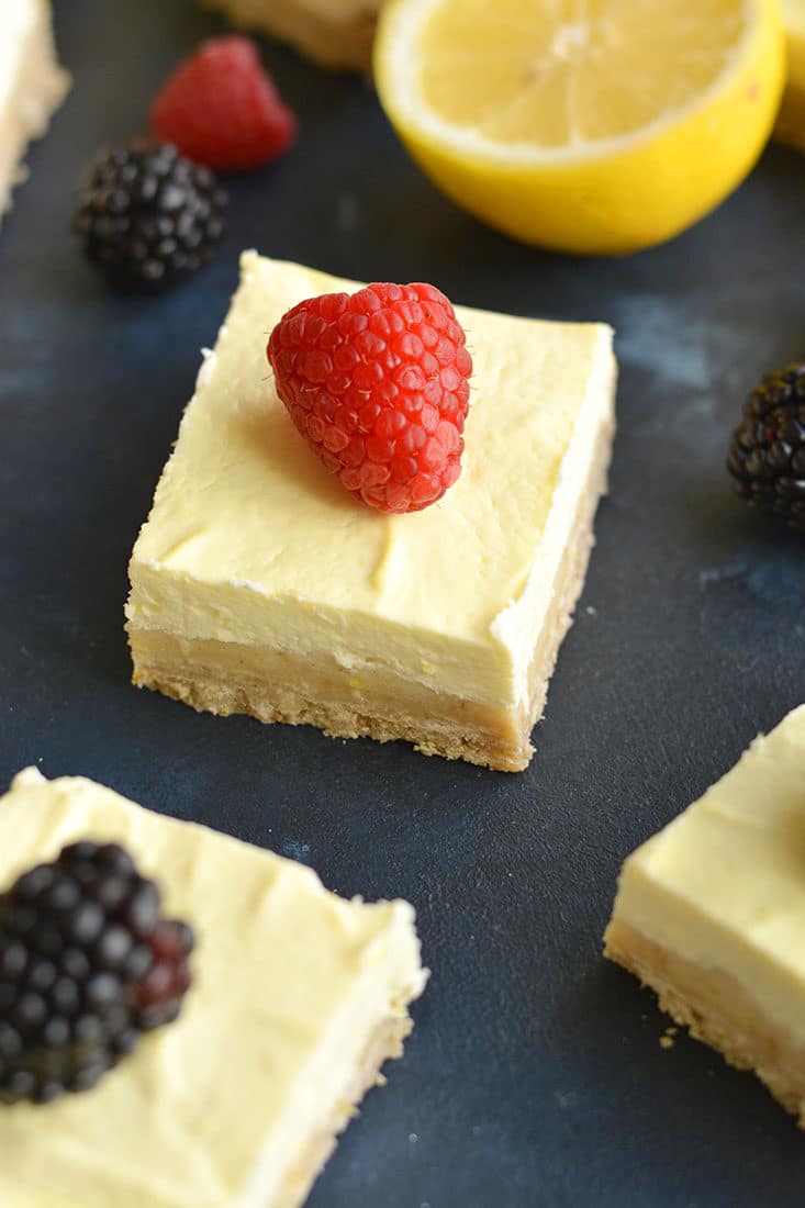 Skinny Greek Yogurt Lemon Bars! These creamy bars have a gluten free shortbread crust with a stevia sweetened Greek yogurt custard layer on top that's bursting with lemon flavor! These lightened up bars are baked to perfection for the ultimate low calorie dessert! Gluten Free + Low Calorie