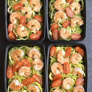 Meal Prep Shrimp Zucchini Noodles! Zesty lemon garlic shrimp is topped over zucchini noodles with sliced tomatoes. Baked on a sheet pan in under 10 minutes! A light, fresh and satisfying low carb meal to take with you on the go! Paleo + Gluten Free + Low Calorie