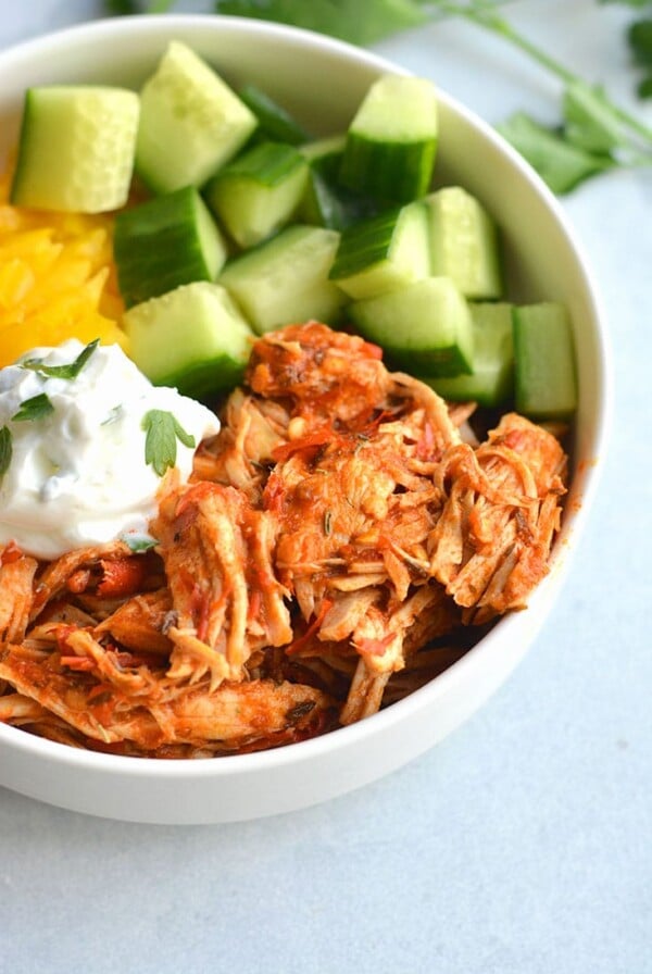 Instant Pot Harissa Shredded Chicken Bowls! This simple, healthy shredded chicken is cooked in under 30 minutes in an Instant Pot with Harissa for a spicy kick! Paired with sliced cucumber, bell pepper and Greek yogurt for a complete meal! Low Calorie + Gluten Free