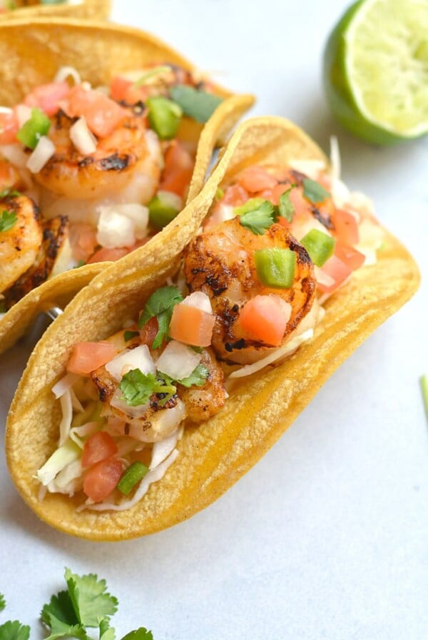 10 Minute Grilled Shrimp Tacos! This lightened up recipe shows you how to do tacos healthier and in a breeze. Grilling shrimp produces delicious flavor and can be easily done with a grill pan. A healthy dinner for busy weeknights or weekend BBQ's! Gluten Free + Low Calorie with a Paleo option