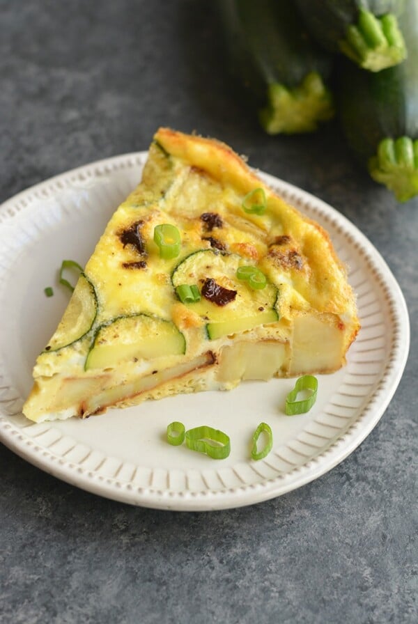 This Lightened Up Spanish Tortilla is loaded with sweet potatoes, zucchini and sun dried tomatoes. A new & lighter twist on a Spanish Tortilla that's easy to make. It's wholesome, light and delicious! Perfect for a holiday, weekend brunch or breakfast meal prep. Paleo + Gluten Free + Low Calorie