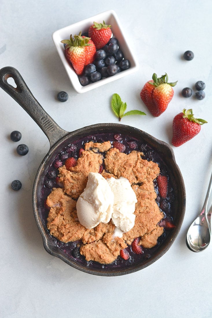 Low Sugar Berry Cobbler is the ultimate summertime treat! Made in one skillet with glycemic friendly ingredients. Low in calories and higher in protein than traditional cobblers, this warm weather dessert is sure to be your new favorite treat. Paleo + Gluten Free Options