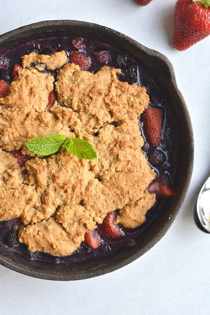 Low Sugar Berry Cobbler is the ultimate summertime treat! Made in one skillet with glycemic friendly ingredients. Low in calories and higher in protein than traditional cobblers, this warm weather dessert is sure to be your new favorite treat. Paleo + Gluten Free Options