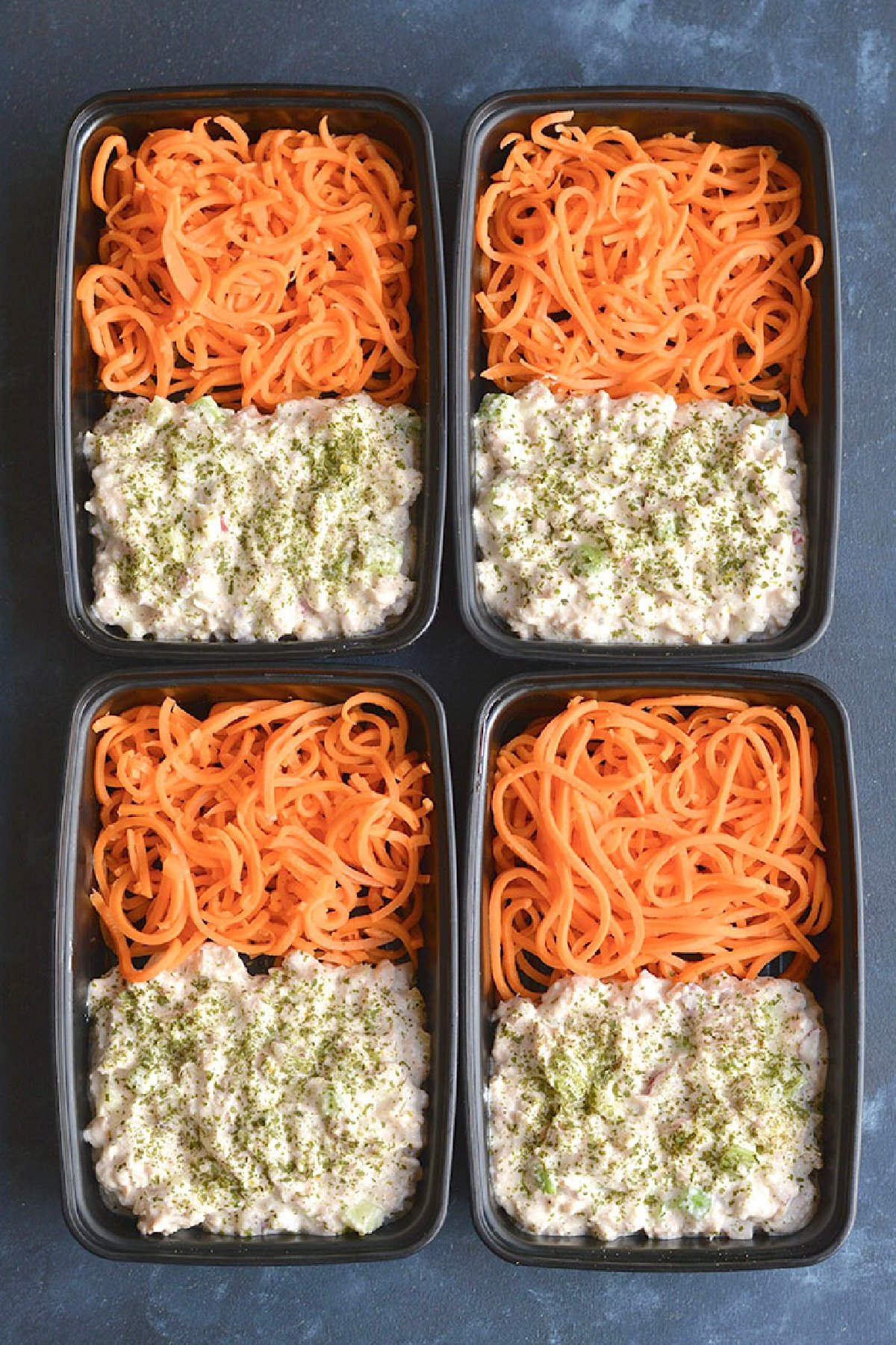 spiralized carrrots and blended cottage cheese with tuna in four meal prep containers.