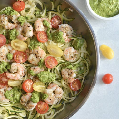 Shrimp Pesto Zucchini Noodles! Traditional spaghetti is replaced with low carb zucchini noodles. A lighter and healthier spin on spaghetti paired with skillet baked shrimp and homemade spinach walnut pesto. High in protein and healthy fat, this easy 30-minute meal is perfect for a quick lunch or dinner. Low Carb + Paleo + Gluten Free + Low Calorie