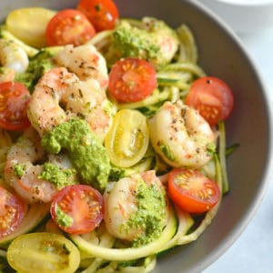 Shrimp Pesto Zucchini Noodles! Traditional spaghetti is replaced with low carb zucchini noodles. A lighter and healthier spin on spaghetti paired with skillet baked shrimp and homemade spinach walnut pesto. High in protein and healthy fat, this easy 30-minute meal is perfect for a quick lunch or dinner. Low Carb + Paleo + Gluten Free + Low Calorie