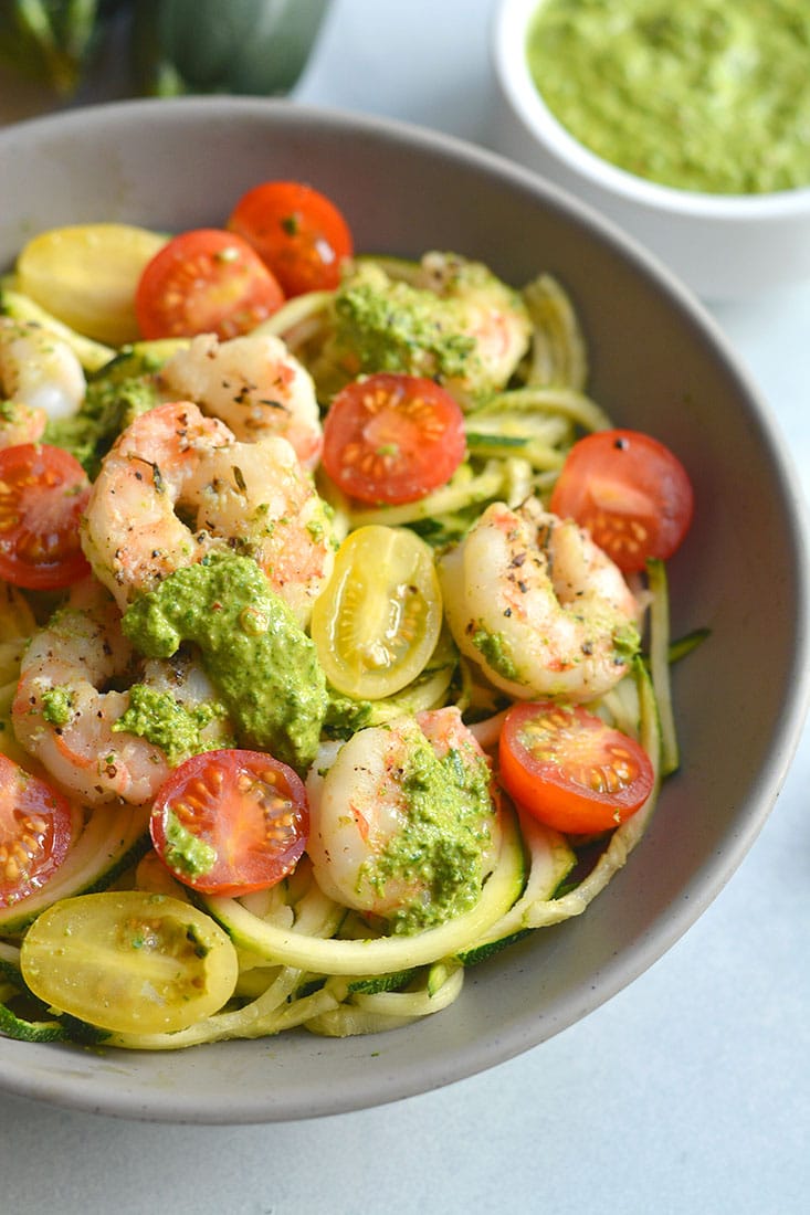 Shrimp Pesto Zucchini Noodles! Traditional spaghetti is replaced with low carb zucchini noodles. A lighter and healthier spin on spaghetti paired with skillet baked shrimp and homemade spinach walnut pesto. High in protein and healthy fat, this easy 30-minute meal is perfect for a quick lunch or dinner. Low Carb + Paleo + Gluten Free + Low Calorie