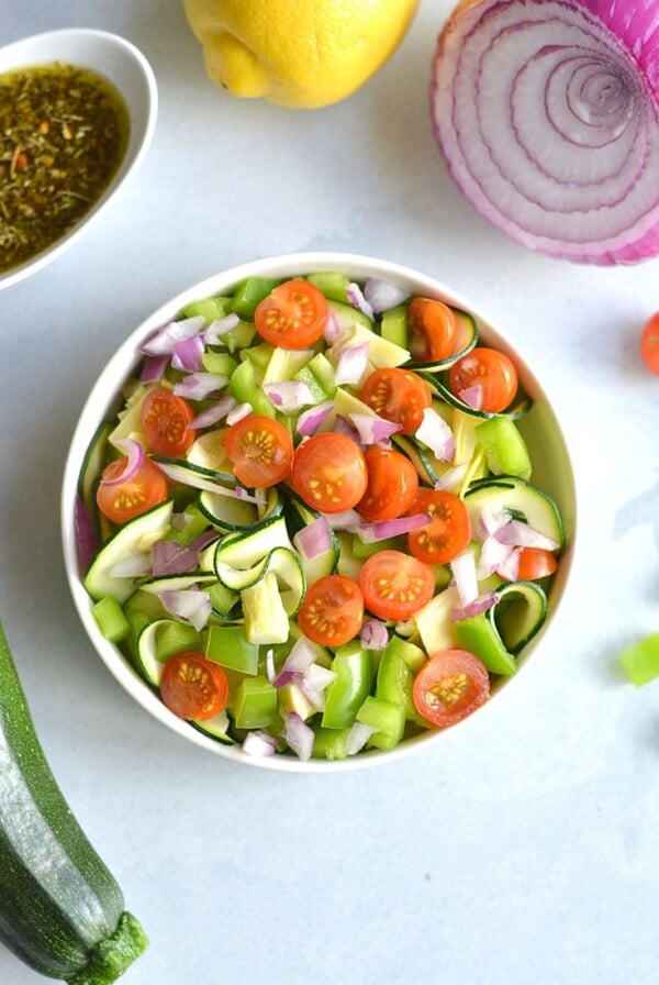 Paleo Zucchini Pasta Salad! Replace pasta with spiralized zucchini for a light, refreshing and filling pasta salad! A low carb pasta salad filled with vegetables. Pair with your favorite lean protein for a complete meal. Low Carb + Gluten Free + Paleo + Low Calorie + Vegan
