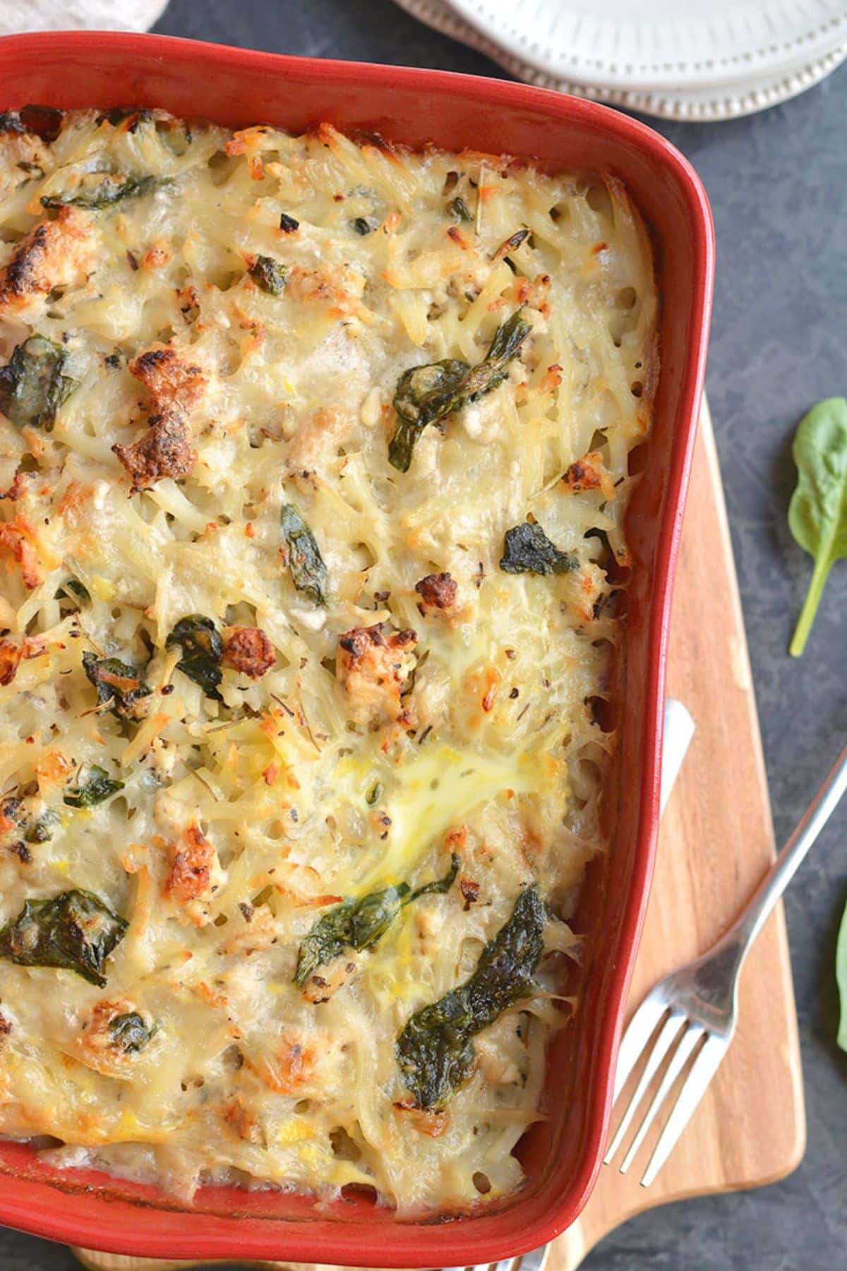 A chicken hash brown casserole on a wooden cutting board.