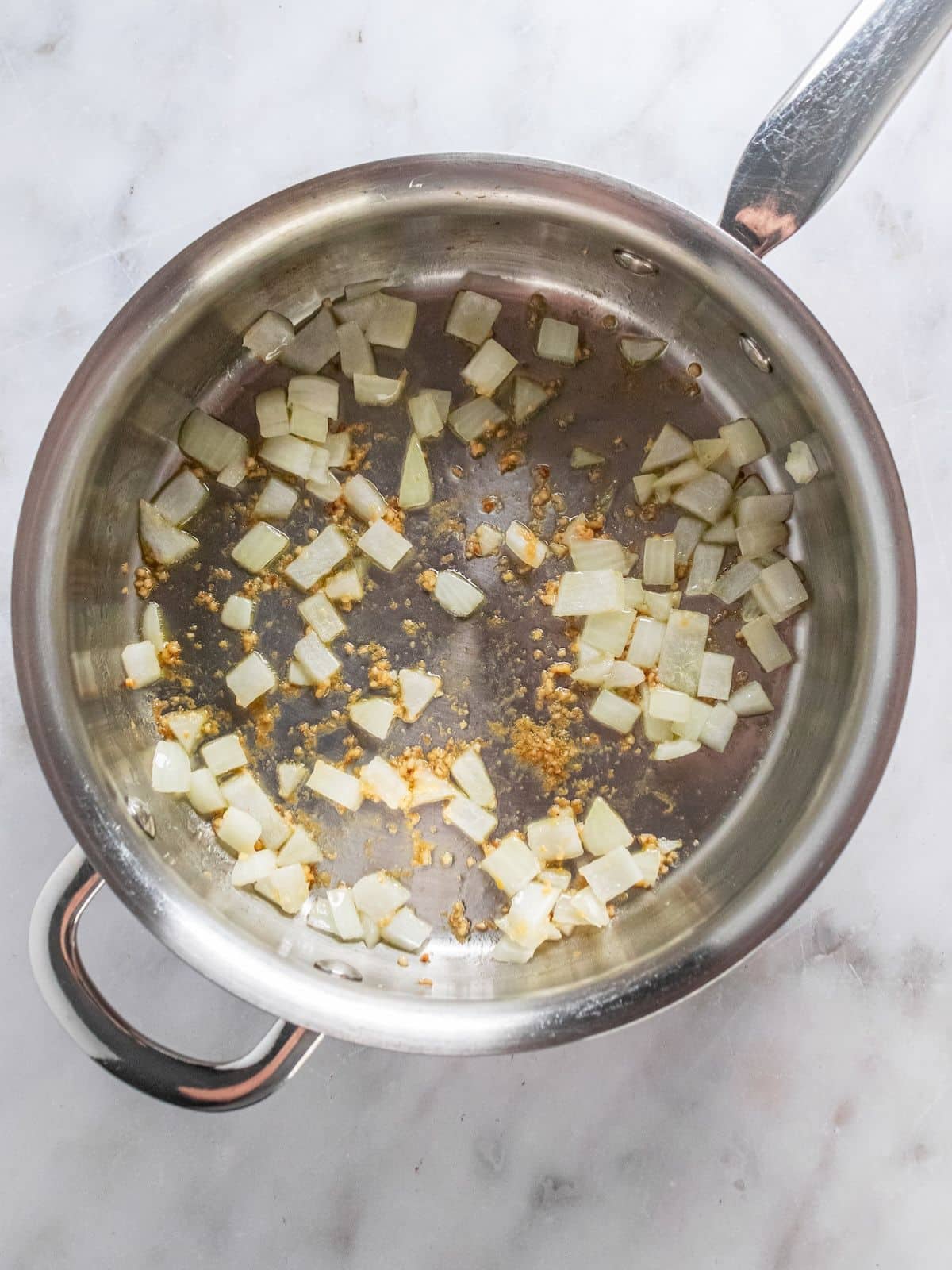 Onions and garlic cooking in a skillet.