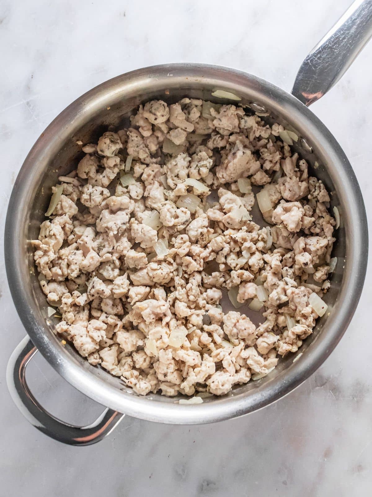 Ground chicken cooking in the skillet.