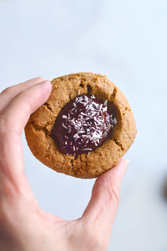 Paleo Raspberry Coconut Thumbprint Cookies! No one will guess these easy to bake coconut and nut butter cookies made with raspberry chia jam are grain free! 