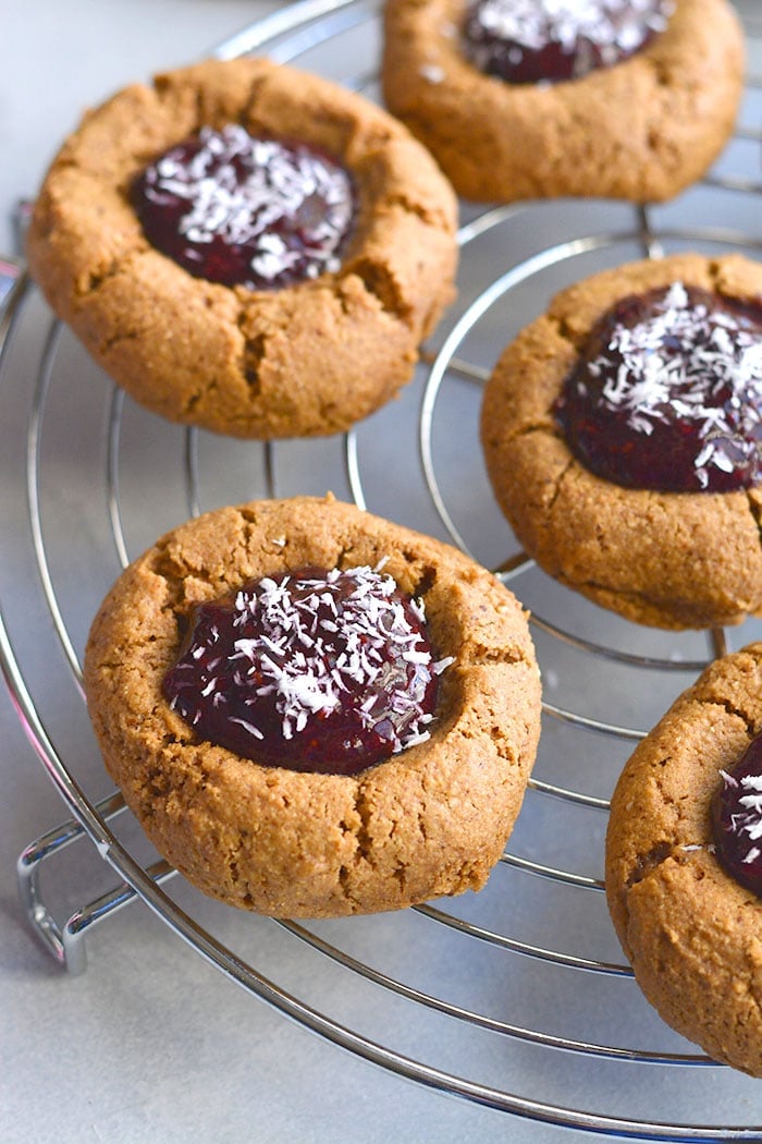 Paleo Raspberry Coconut Thumbprint Cookies! No one will guess these easy to bake coconut and nut butter cookies made with raspberry chia jam are grain free!