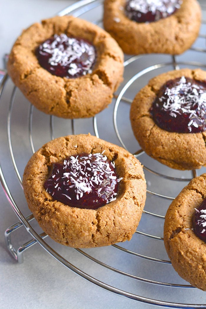 Paleo Raspberry Coconut Thumbprint Cookies! No one will guess these easy to bake coconut and nut butter cookies made with raspberry chia jam are grain free! 