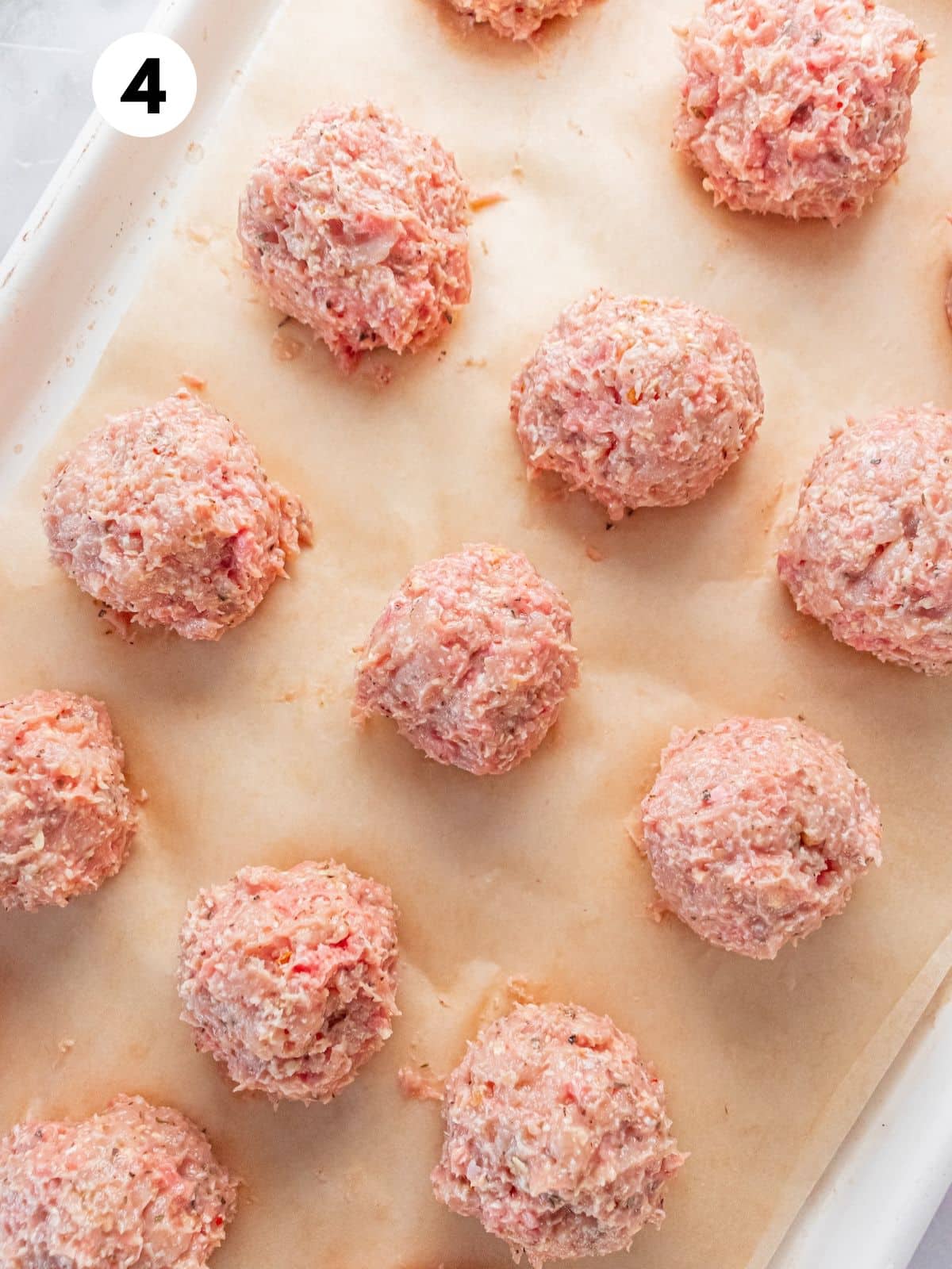 Turkey meatballs shaped on a baking pan.