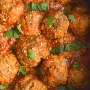 Crockpot turkey meatballs in tomato sauce garnished with chopped herbs.