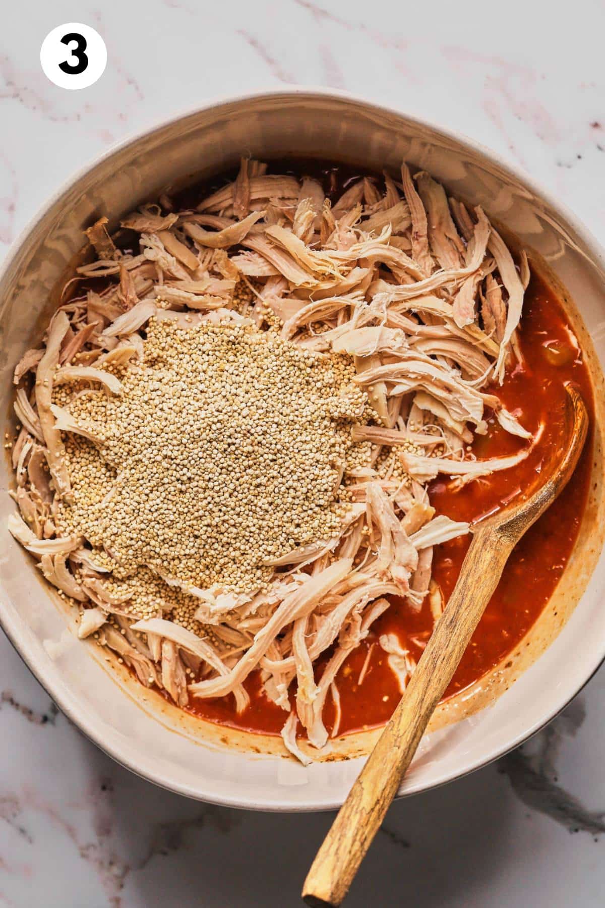 Add the quinoa and shredded chicken to the sauce in the bowl.