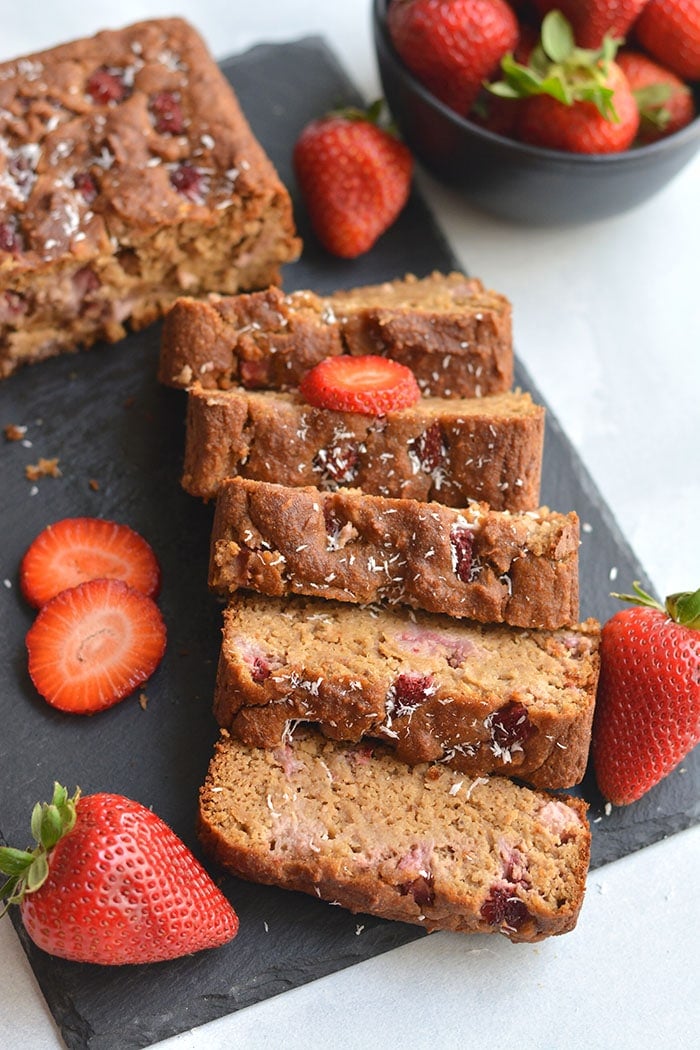 Gluten Free Strawberry Banana Bread! Made with Greek yogurt, packed with fresh berries and naturally sweetened with bananas and coconut flakes. The perfect bread for summer breakfast or snacks. Gluten Free + Low Calorie 