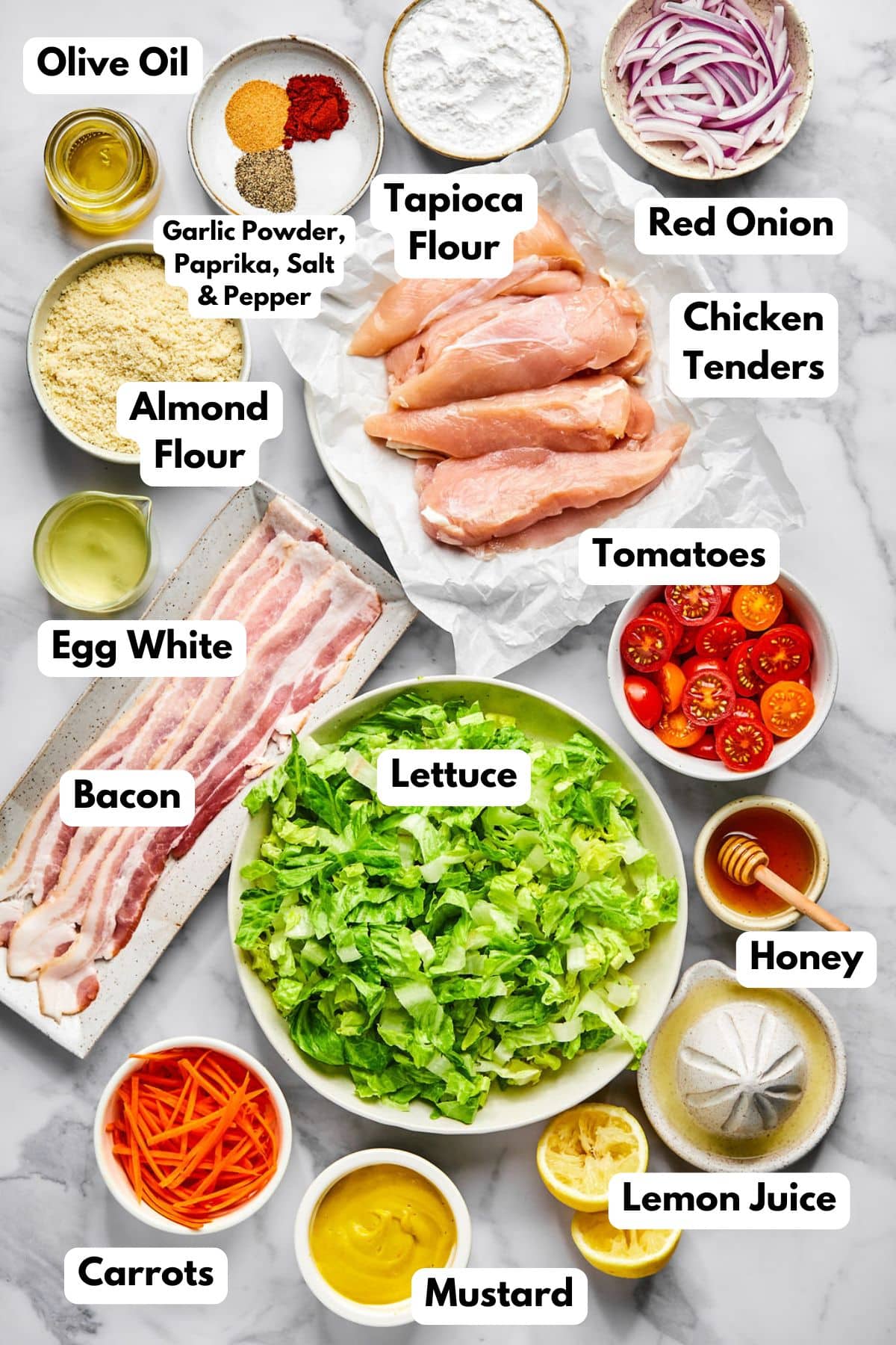 Ingredients in bowls on a flat surface with text labels to identify each. 