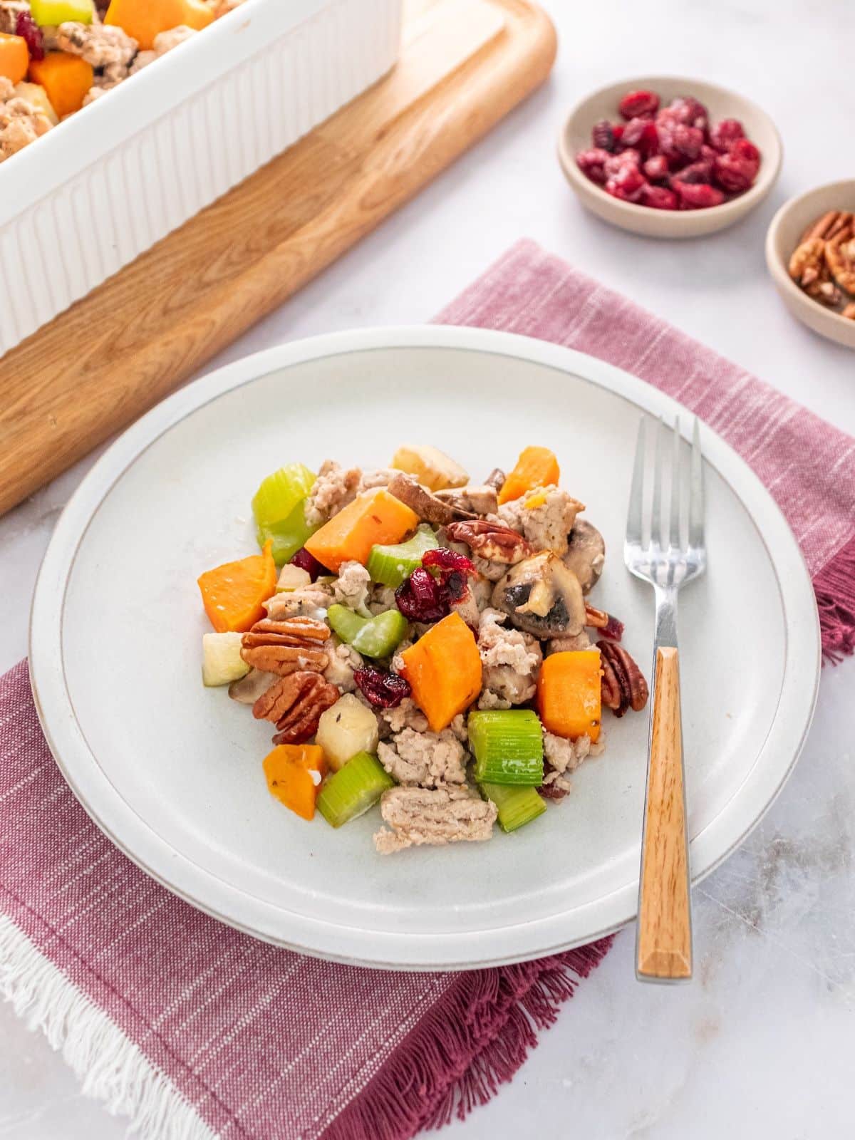 Gluten-free stuffing recipe on a plate with a fork resting on the side.