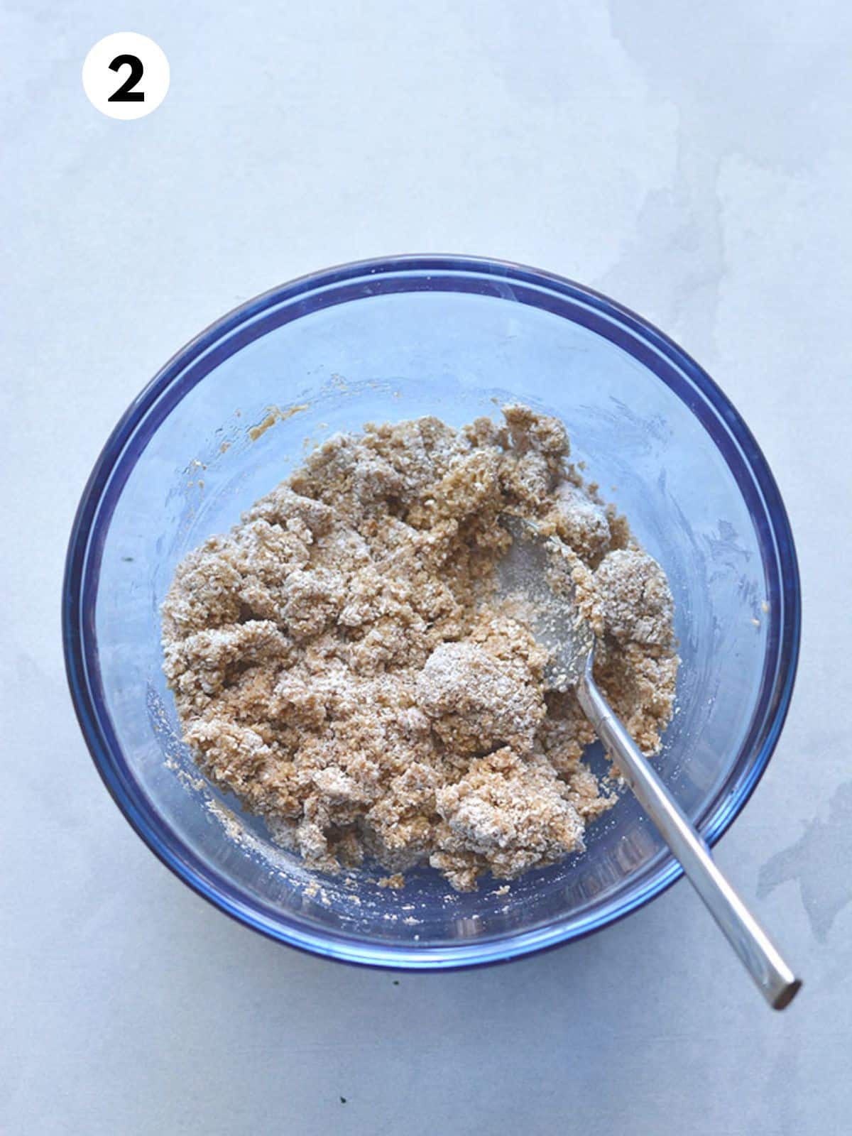 Pie crust ingredients mixed together in a glass bowl.