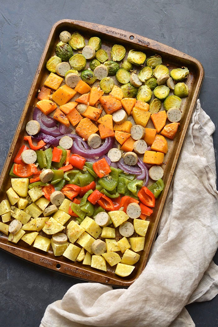 Sheet Pan Sausage and Veggies! Sugar free sausage, Brussels sprouts, butternut squash, sweet potato, red pepper and onion baked together on a sheet pan. A quick, healthy and filling 30-minute meal. Paleo + Gluten Free + Low Calorie