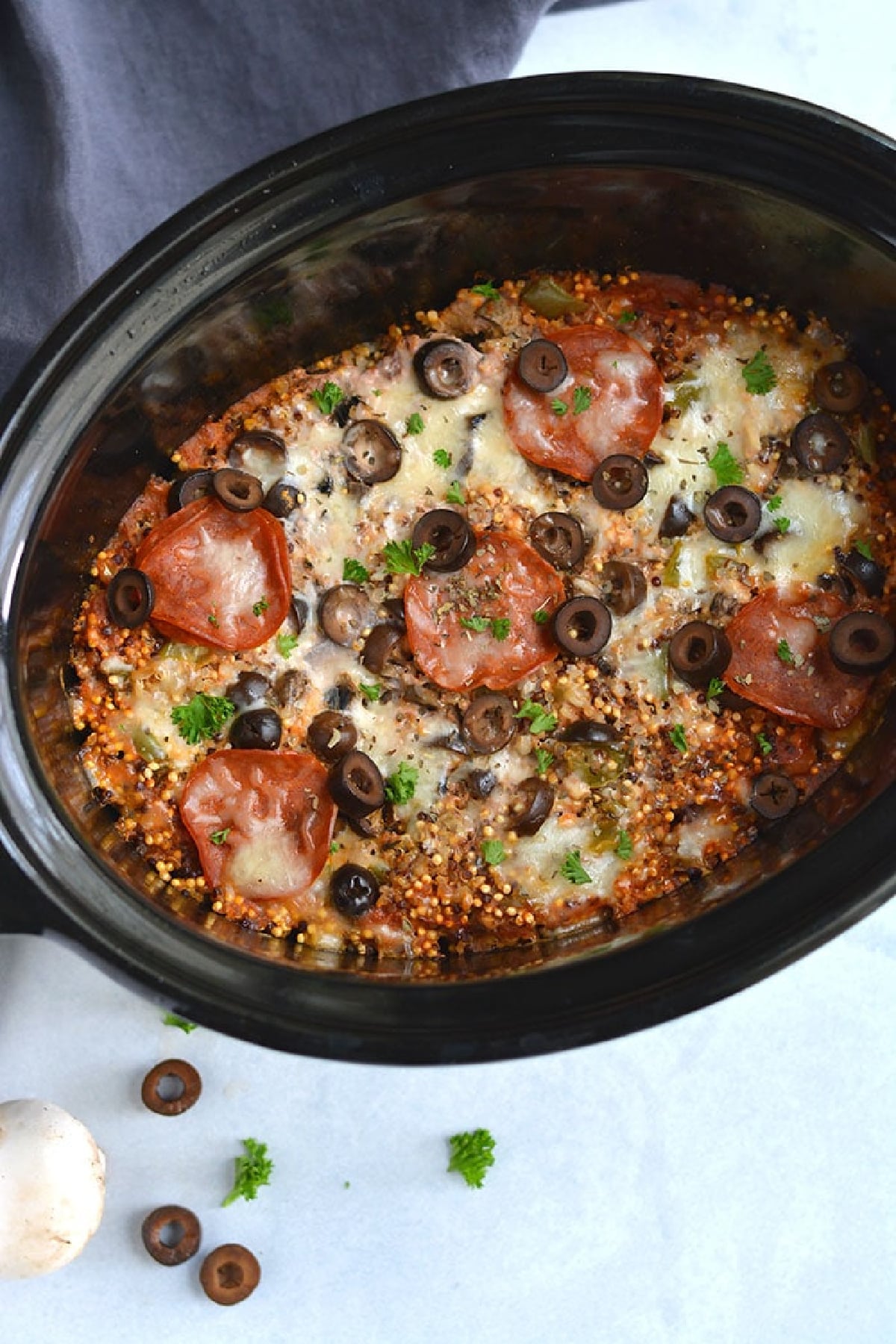 pepperoni on top of cooked quinoa in a slow cooker.