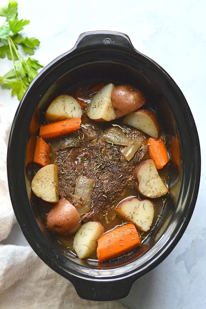 Healthy Crockpot Pot Roast! The BEST slow cooked pot roast you will ever eat. Perfectly tender, juicy and delicious! Served with carrots and potatoes for an easy meal. Gluten Free + Low Calorie