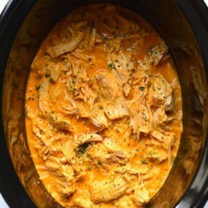 Healthy Crockpot Buffalo Chicken with just 4 ingredients! Chicken slow cooked in a secret high protein sauce make super tender and juicy shredded chicken. An easy recipe for meal prep. Low Carb + Low Calorie + Gluten Free