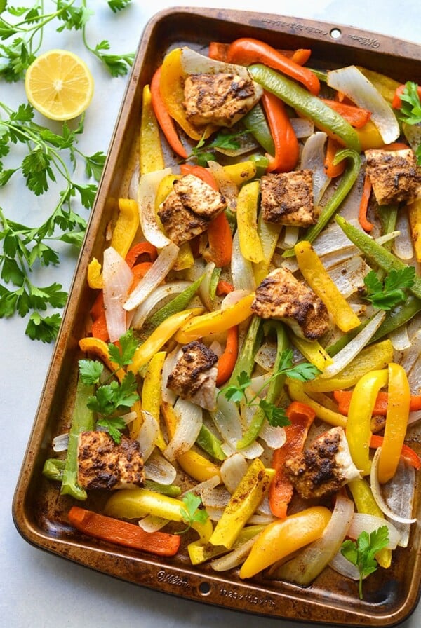 Healthy Sheet Pan Fish Fajitas! This dinner recipe is made in under 30 minutes with veggies and seasoned fish! An easy, healthy weeknight meal that's perfect for feeding a crowd or one. Paleo + Gluten Free + Low Calorie + Low Carb
