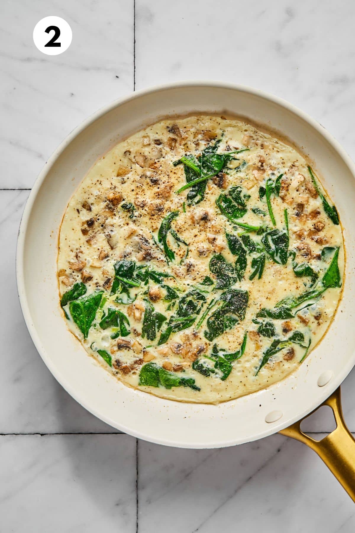 Egg whites are added to the skillet to cook with the vegetables. 