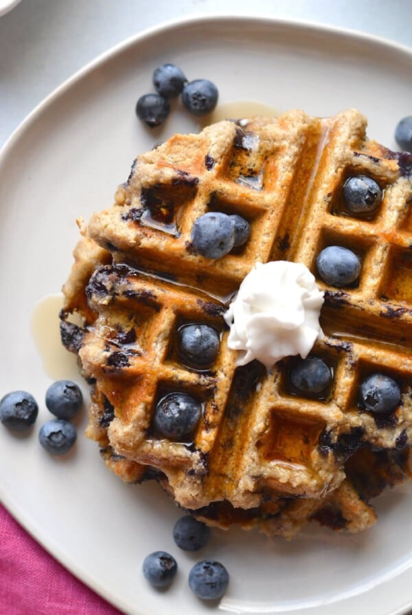 waffle with blueberries and whipped cream on top.