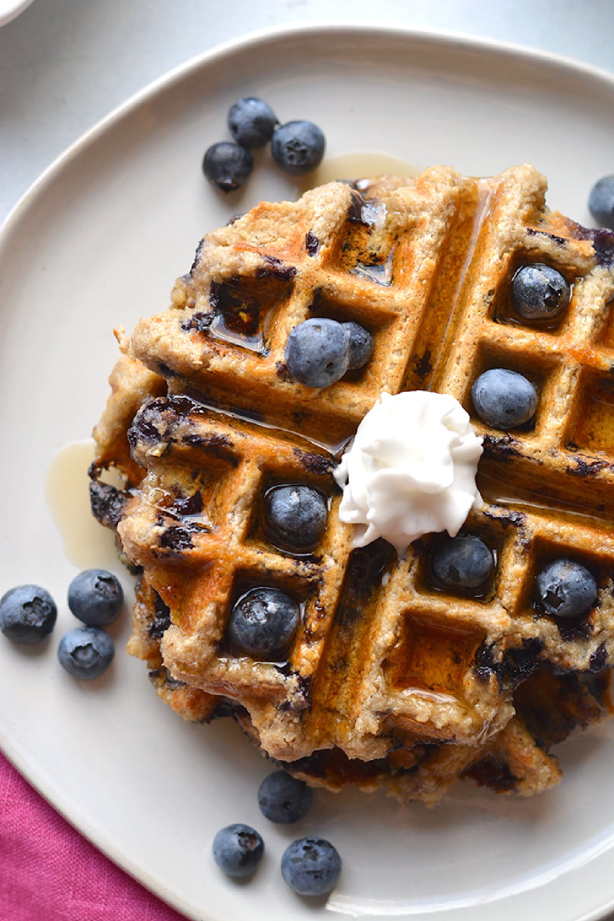 waffle with blueberries and whipped cream on top.