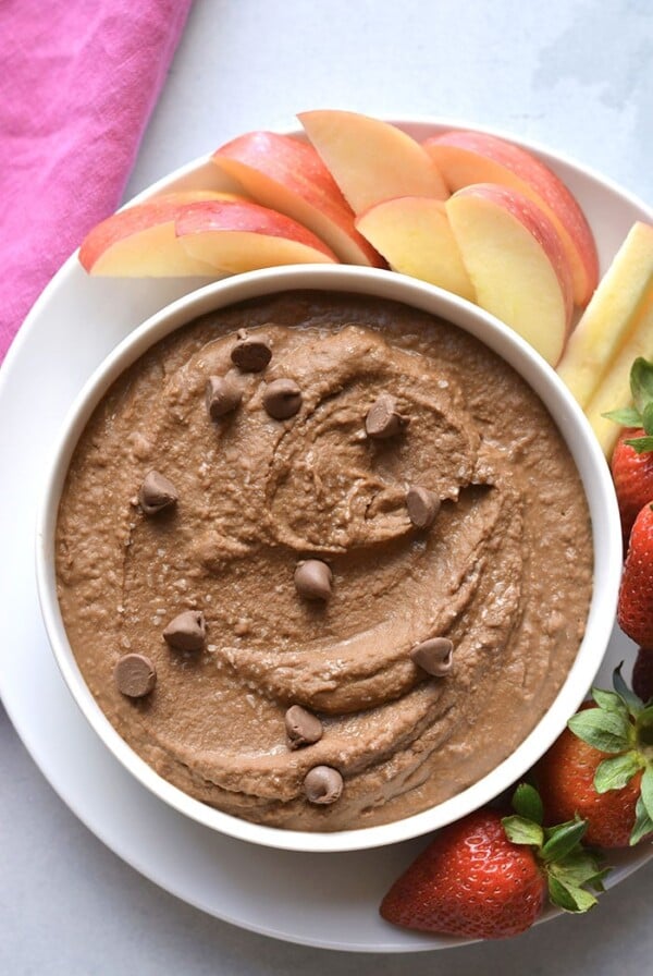 chocolate hummus in a white bowl with fruit