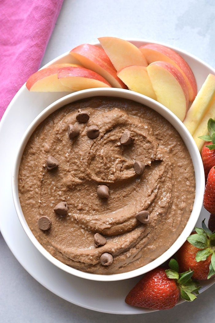 chocolate hummus in a white bowl with fruit