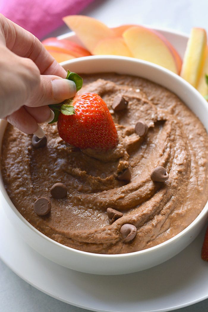 strawberry dipped into chocolate hummus