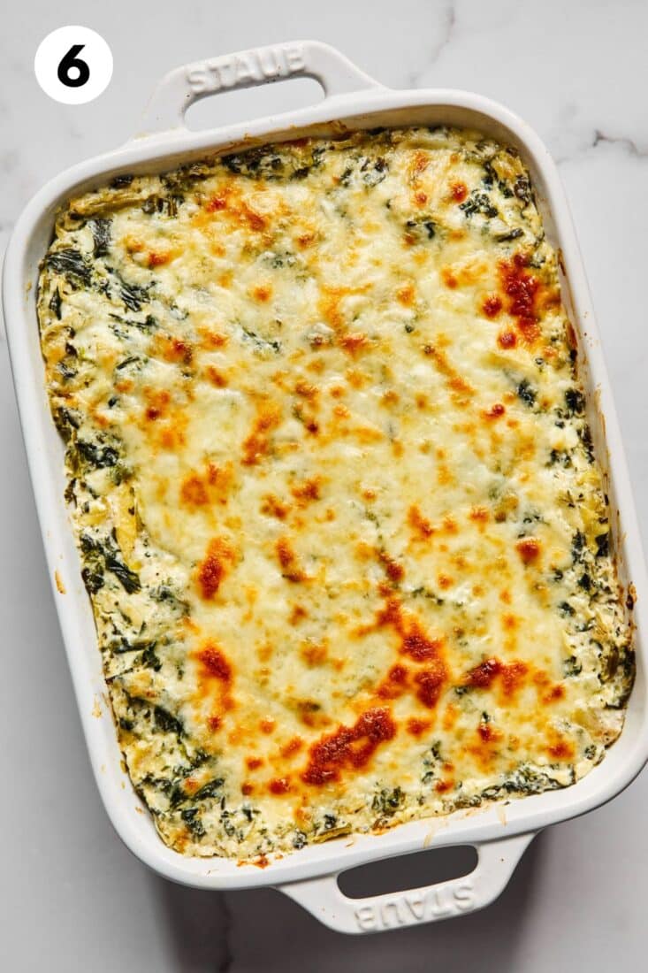 Baked cottage cheese spinach artichoke dip on the table.