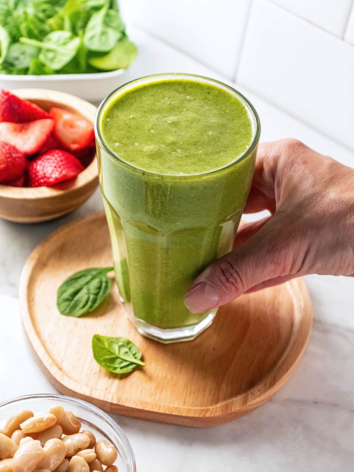 A hand grabbing a high fiber smoothie.
