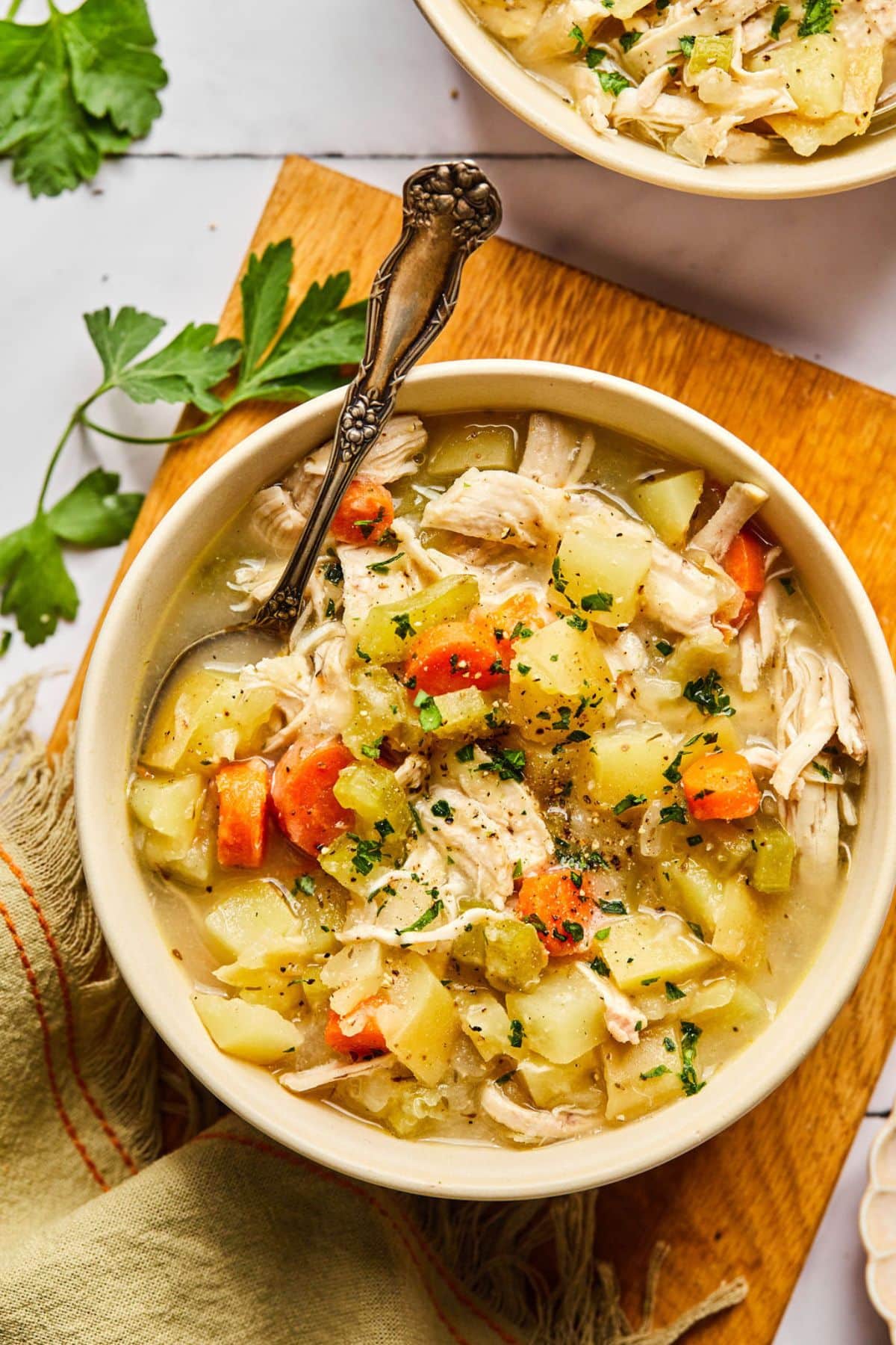 A bowl of chicken pot pie soup with a spoon in the bowl.