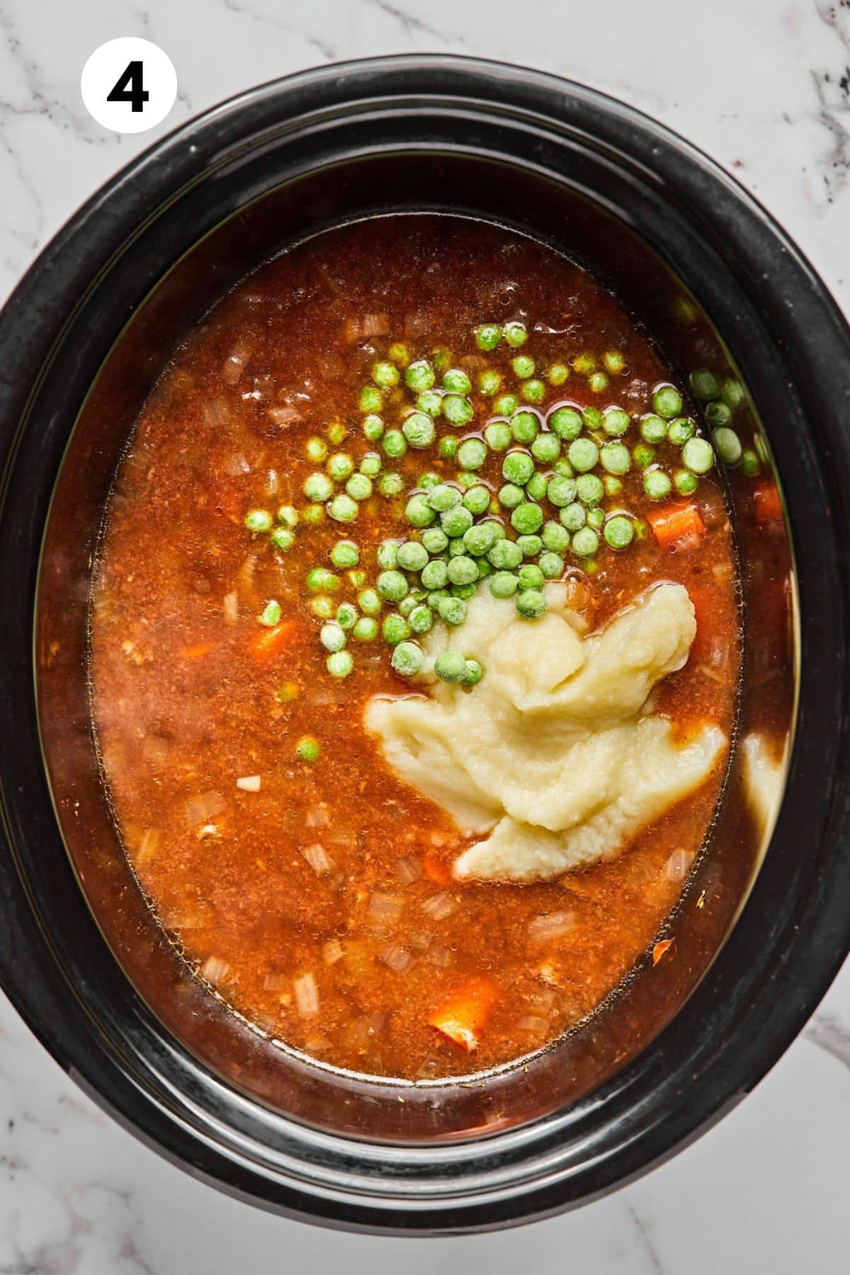 Peas and mashed cauliflower added to the slow cooker.