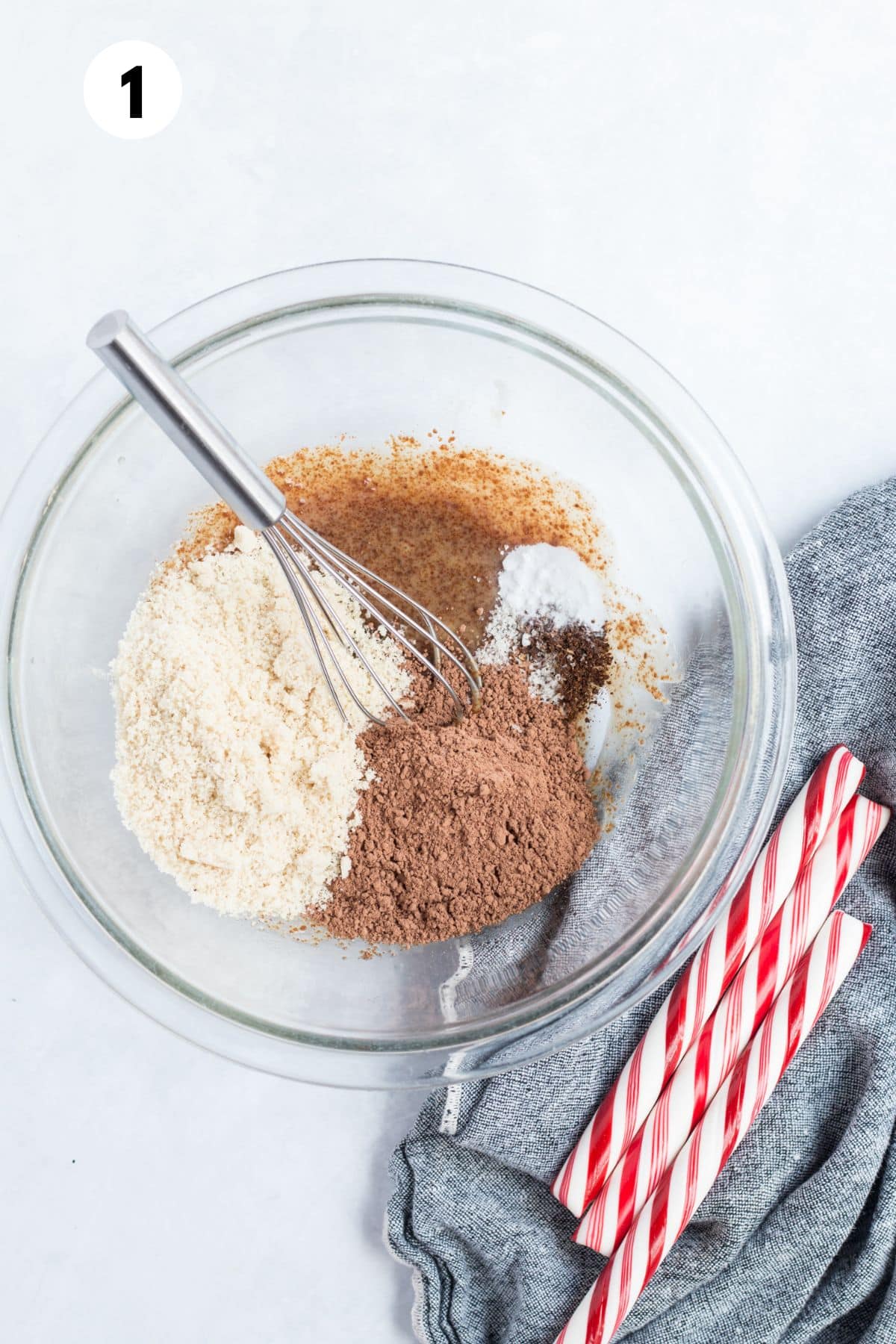 Ingredients for making chocolate thumbprint cookies together in a glass mixing bowl.