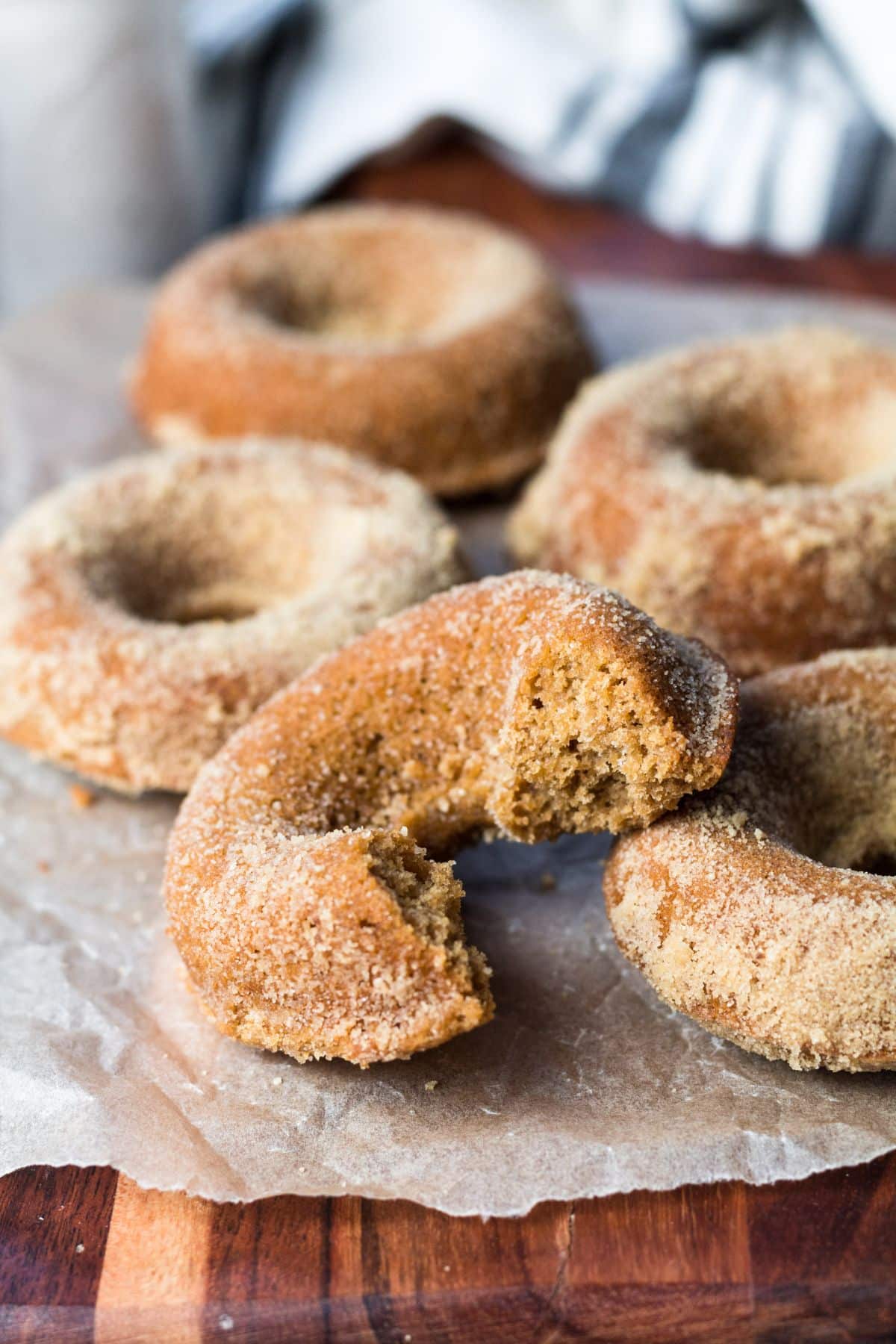 Gingerbread donuts on a table with one that has a bite taken out of it.