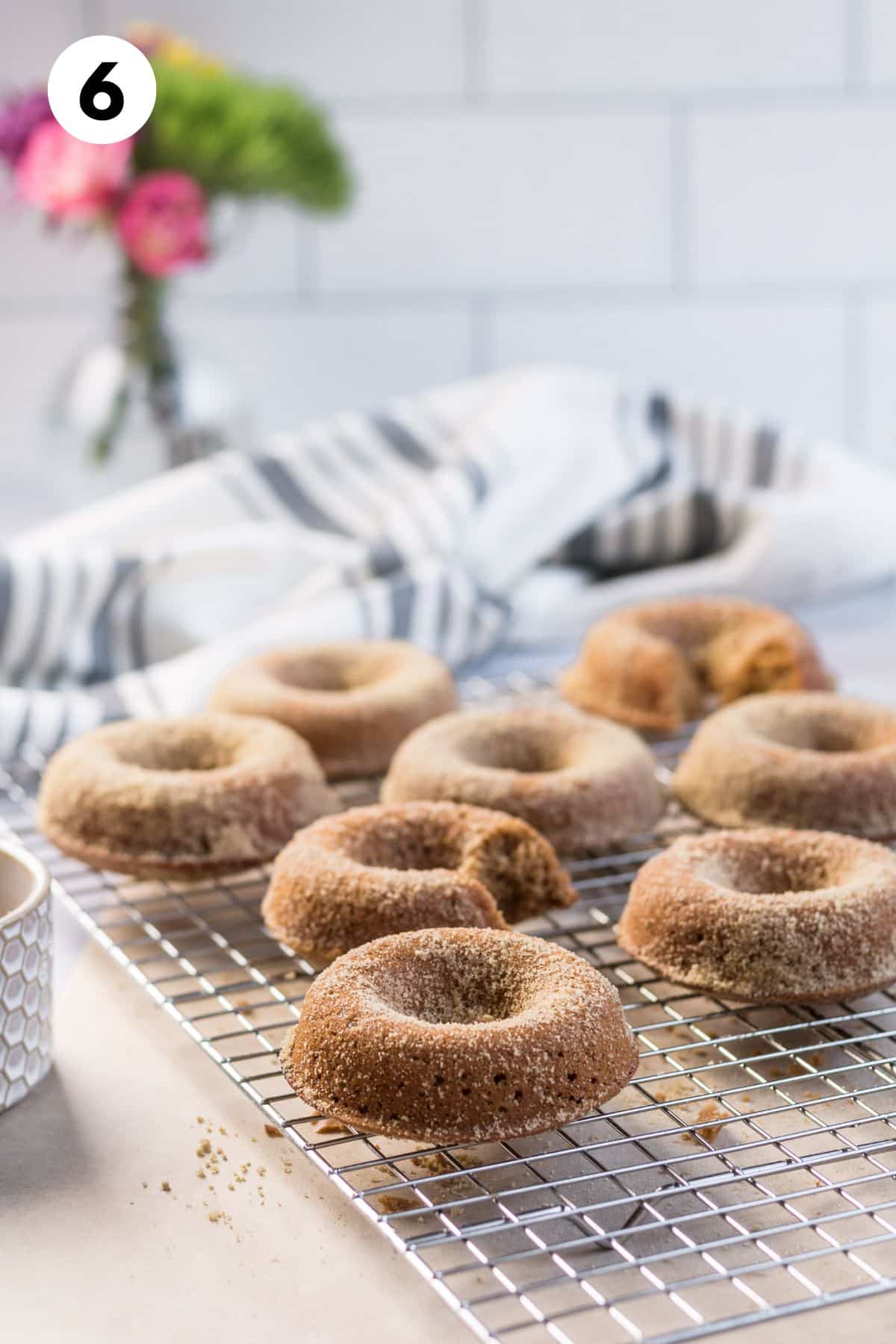 Sugar coated gingerbread donuts on a cooling rack.