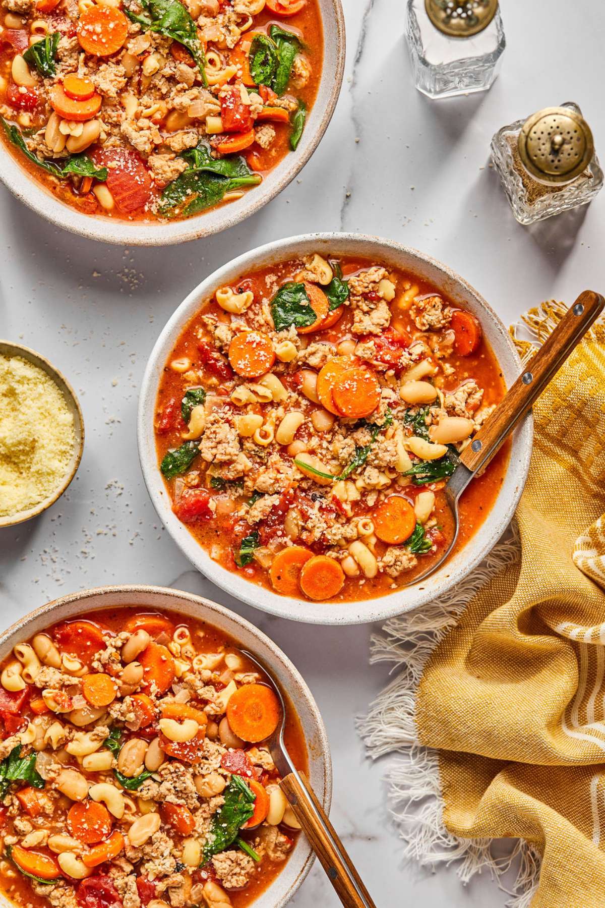 Three bowls of healthy pasta e fagioli soup on the table. 